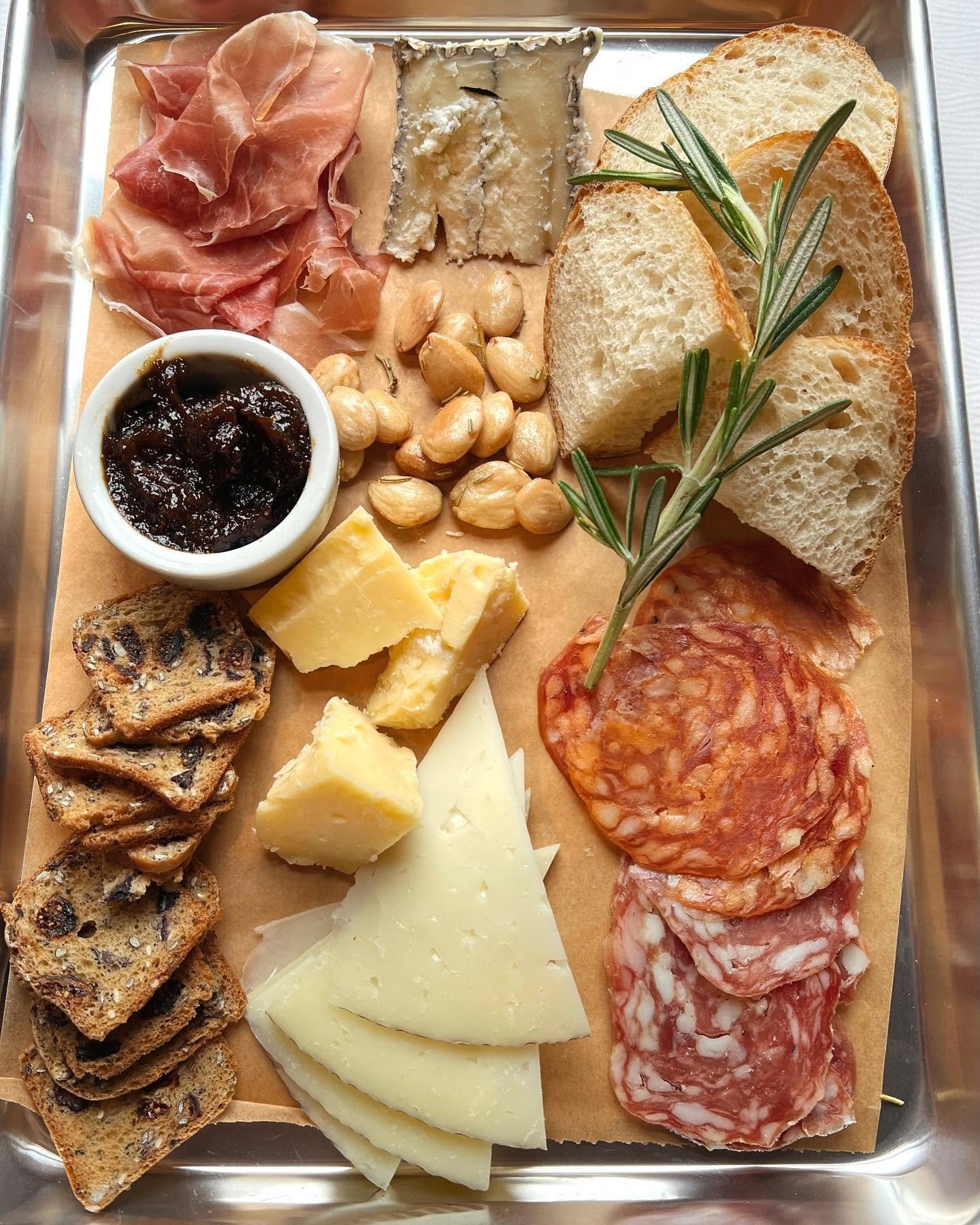 Charcuterie and cheese board with prosciutto, salami, cheeses, nuts and jam